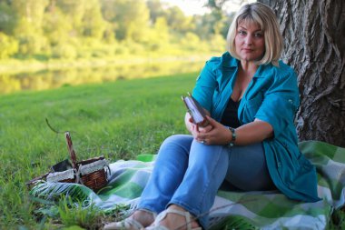 kadınla çimenlerin üzerinde kitapla Park