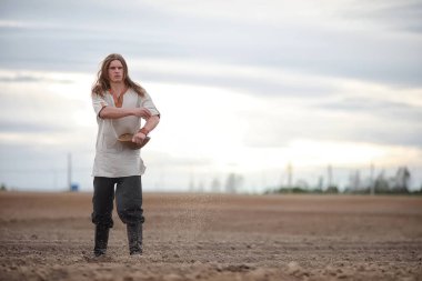 Genç bir köylü tahıl alanıyla sows