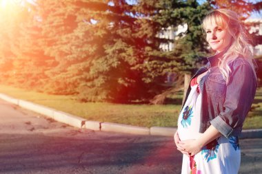 Hamile kız parkta bir yürüyüş. CI karnından kızla