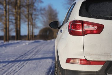 Kış parkındaki karla kaplı yolda beyaz araba manzarası