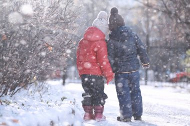 Çocuklar parkta ilk kar yürümek