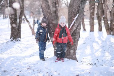 Çocuklar parkta kuşları besler. 