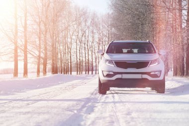 Kış parkındaki karla kaplı yolda beyaz araba manzarası  