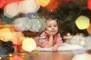 Yeni yıl Noel atmosferinde küçük bir kız. Kız happ olduğunu