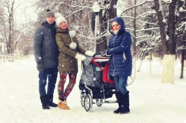 Kış parkında bebek arabasıyla gezen arkadaşlar
