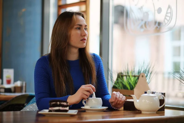 Ung flicka i café sitter och dricker te — Stockfoto