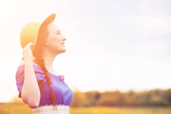 Mooie meisje in jurken op aard. Een meisje in een hoed wandelingen — Stockfoto