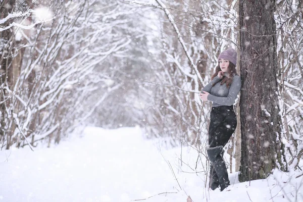 Flicka i en vinterpark i snöfall — Stockfoto