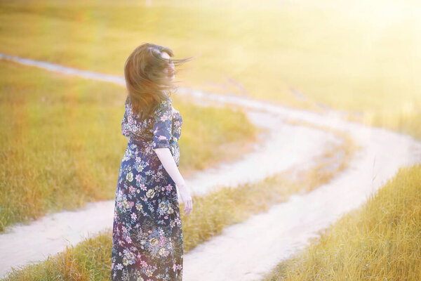 Pregnant girl in a dress in nature on a walk