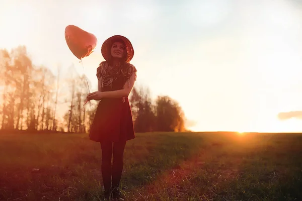 Una ragazza con un cappello mentre passeggia nel parco. Una ragazza con un cesto a piedi — Foto Stock