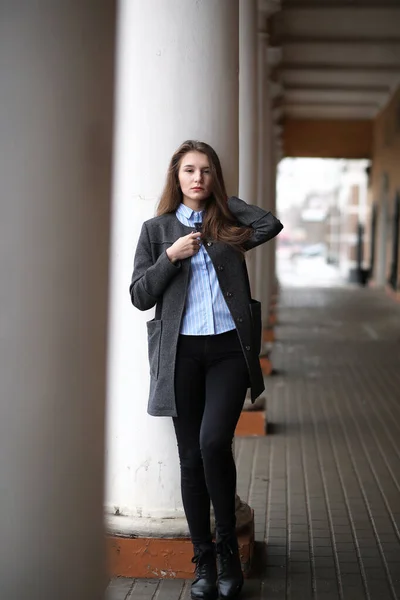 Giovane bella ragazza in una passeggiata vicino edificio con una colonna — Foto Stock