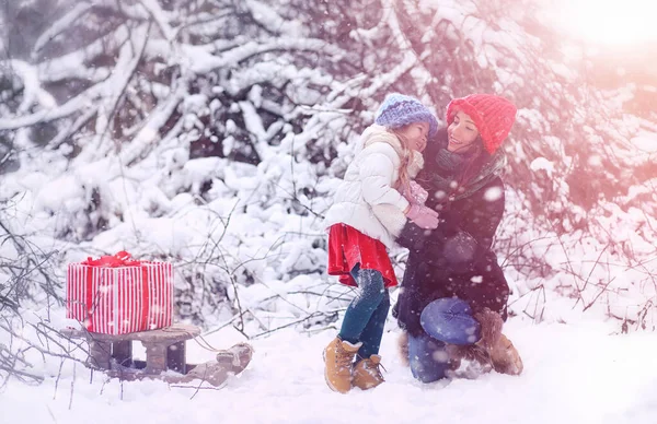 Um conto de fadas de inverno, uma jovem mãe e sua filha montam um trenó — Fotografia de Stock