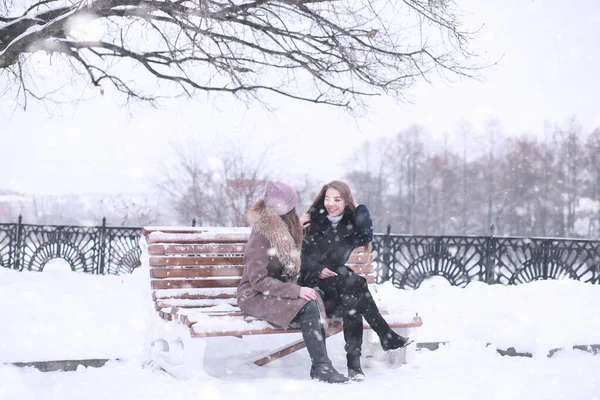 Menina em um parque de inverno na queda de neve — Fotografia de Stock