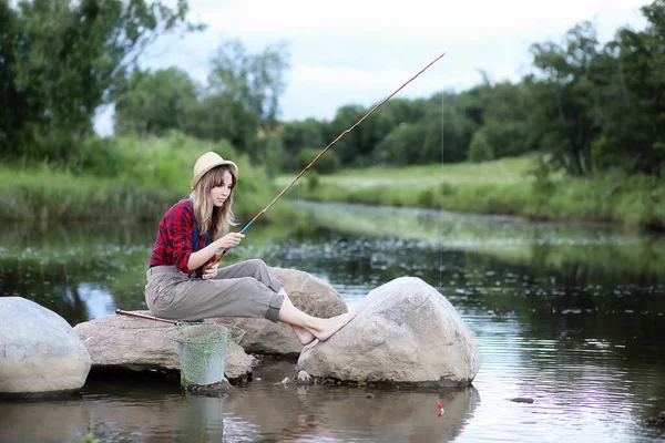 Flickan vid floden med ett fiskespö — Stockfoto