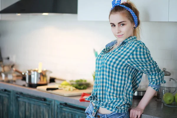 Una linda joven en la cocina prepara comida —  Fotos de Stock
