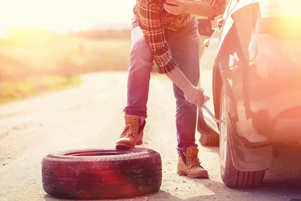 Man sitter på vägen av bilen — Stockfoto