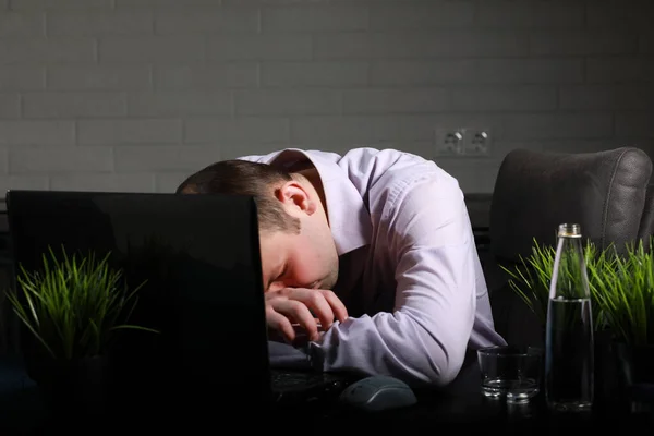 Mann sitzt am Tisch und arbeitet am Laptop — Stockfoto