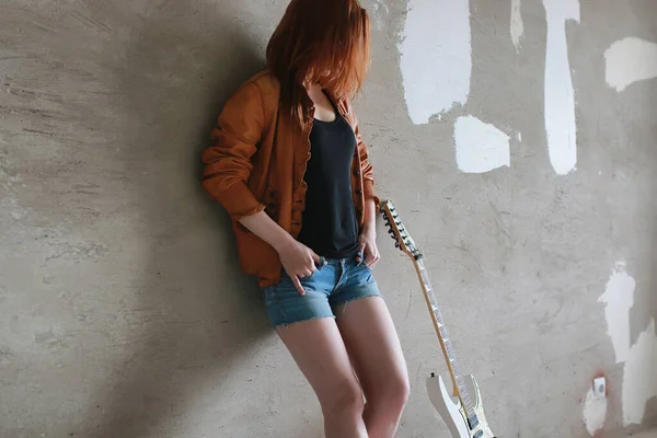 Молодая рыжая девушка с электрогитарой. Рок-музыкант — стоковое фото