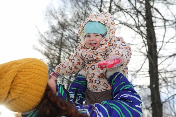 Föräldrar som håller barn på händerna i vinterparken — Stockfoto