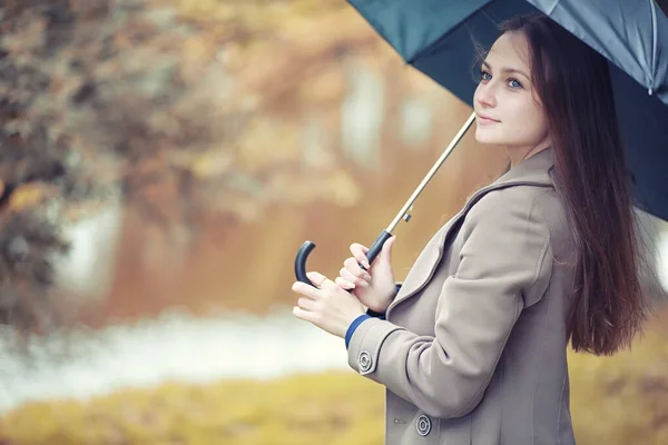 Outono tempo chuvoso e um jovem com um guarda-chuva — Fotografia de Stock