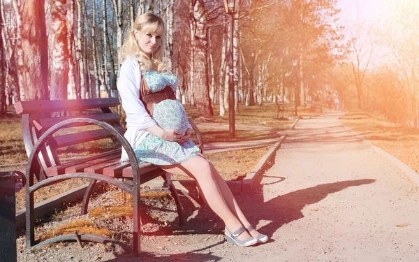 Gravid flicka på en promenad i parken. Flicka med en mage i ci — Stockfoto