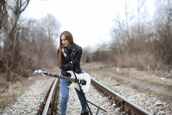 Дівчина рок-музиканта в шкіряній куртці з гітарою — стокове фото