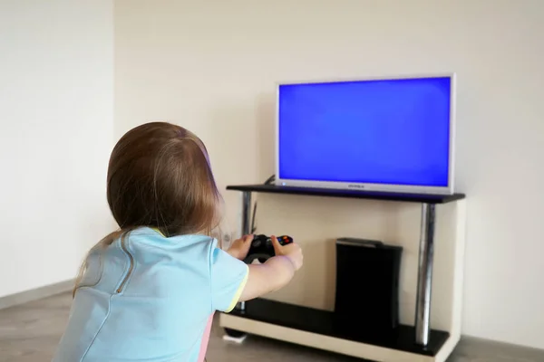 Gadis muda bermain di depan TV — Stok Foto