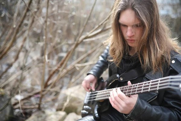 Guitarrista de rock nos degraus. Um músico com uma guitarra baixo em um — Fotografia de Stock