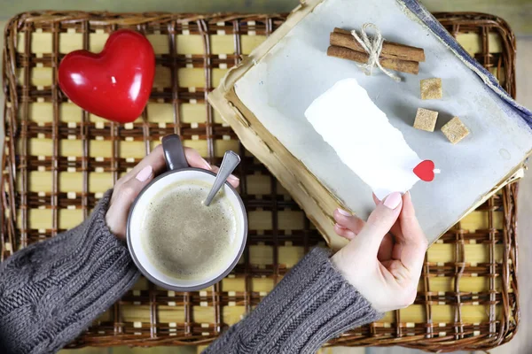 Girl drinking coffee and looking at the card Valentine's Day — Stock Photo, Image