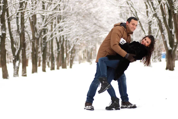 Una joven pareja camina en un parque de invierno —  Fotos de Stock