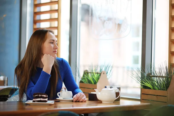 Junges Mädchen sitzt im Café und trinkt Tee — Stockfoto