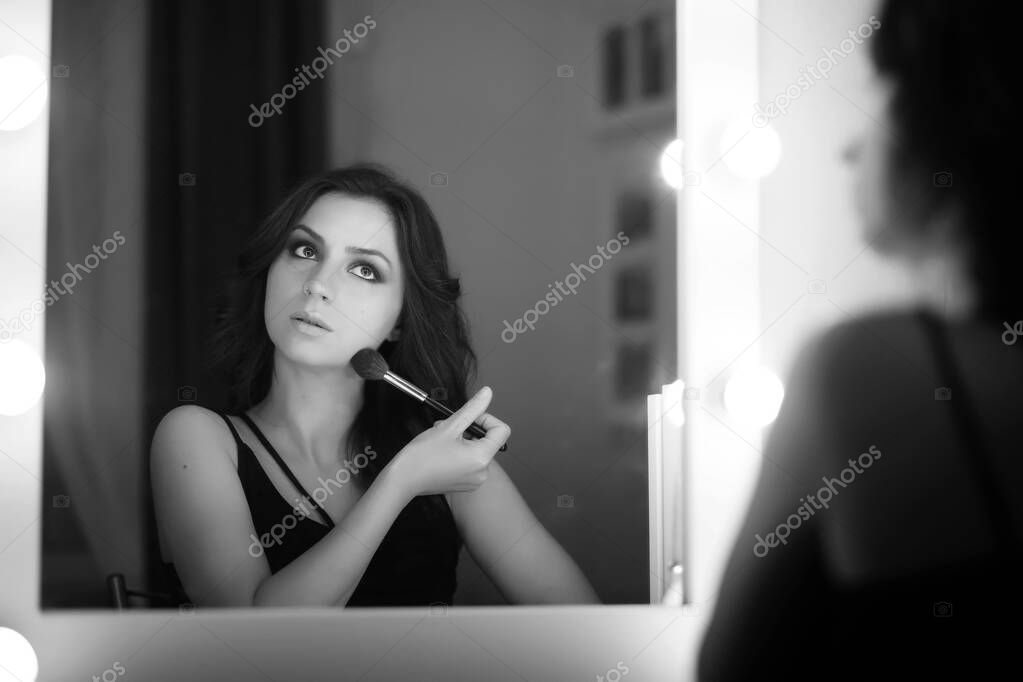 Girl doing makeup black and white