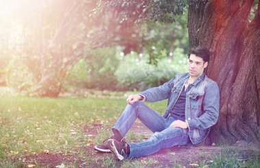 Genç bir adam öğle yemeği zamanında parkta yürür. Bir adam yürüyüşe çıktı. 