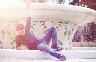 Genç bir adam öğle yemeği zamanında parkta yürür. Bir adam yürüyüşe çıktı. 