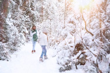 Genç bir aile yürüyüşe çıktı. Anne ve kızı şarapla yürüyorlar.