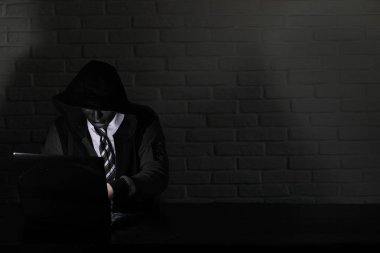 Siyah maske ve hood masada hacker