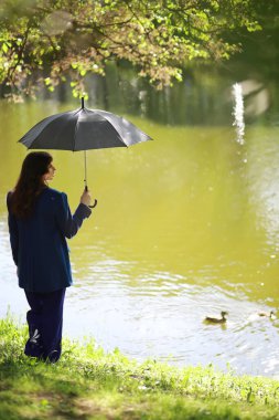 Hamile bir kadın parkta yürüyor.