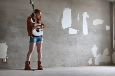 Kızıl saçlı kız bir elektro gitar ile. Rock müzisyen GIR