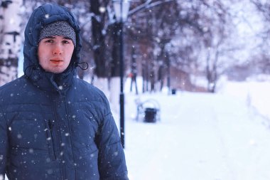 Adam kış parkında yürüyor.