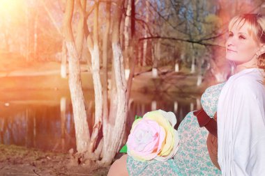 Hamile kız parkta bir yürüyüş. CI karnından kızla