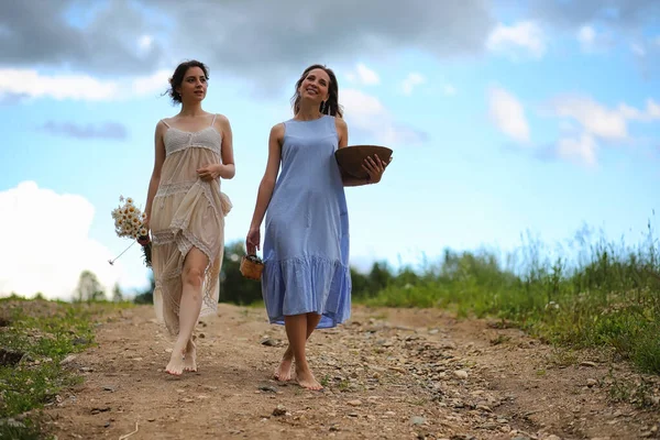 Twee meisjes in jurken in zomer veld — Stockfoto