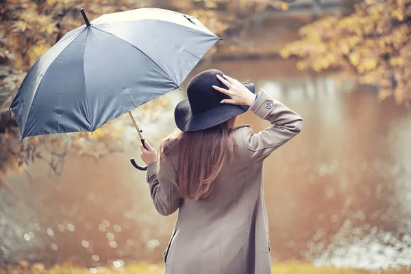 Herbstliches Regenwetter und ein junger Mann mit Regenschirm — Stockfoto