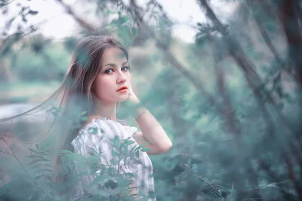 Uma menina em um parque verde primavera — Fotografia de Stock