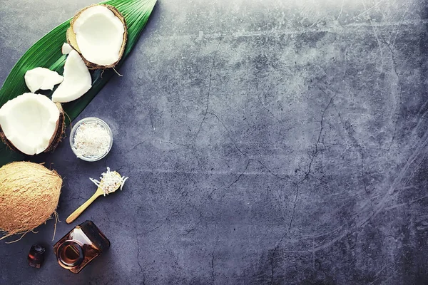 Coco em uma mesa de pedra escura. Óleo de coco . — Fotografia de Stock