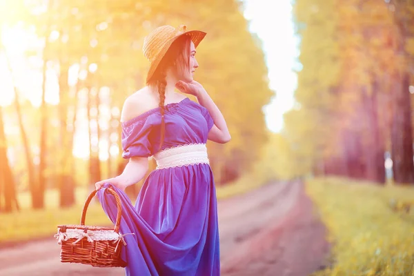 Ung vacker flicka i klänningar på naturen. En tjej i en hatt går — Stockfoto