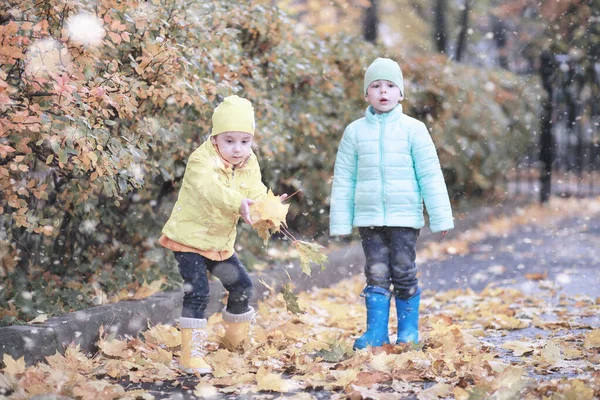 Crianças caminham no parque primeira neve — Fotografia de Stock