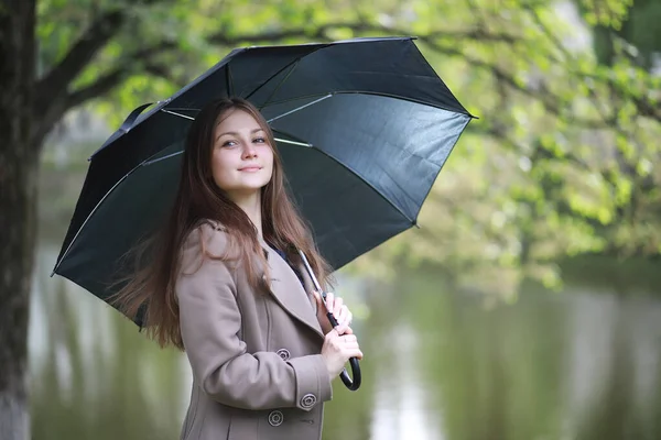 Fiatal lány, egy kabát, egy tavaszi parkban — Stock Fotó