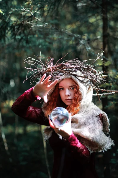 La sorcière rousse tient un rituel avec une boule de cristal — Photo