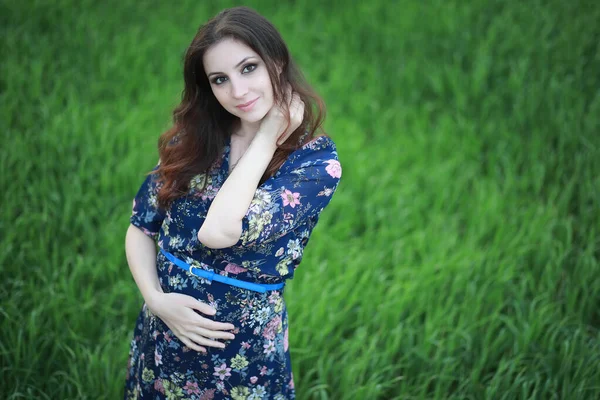 Έγκυος κορίτσι σε ένα φόρεμα στη φύση — Φωτογραφία Αρχείου