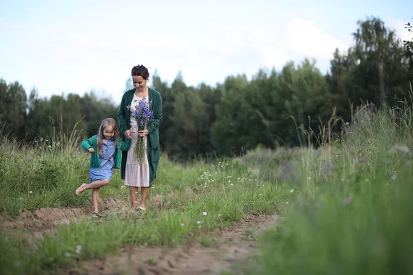 Mère avec sa fille marchant sur une route — Photo